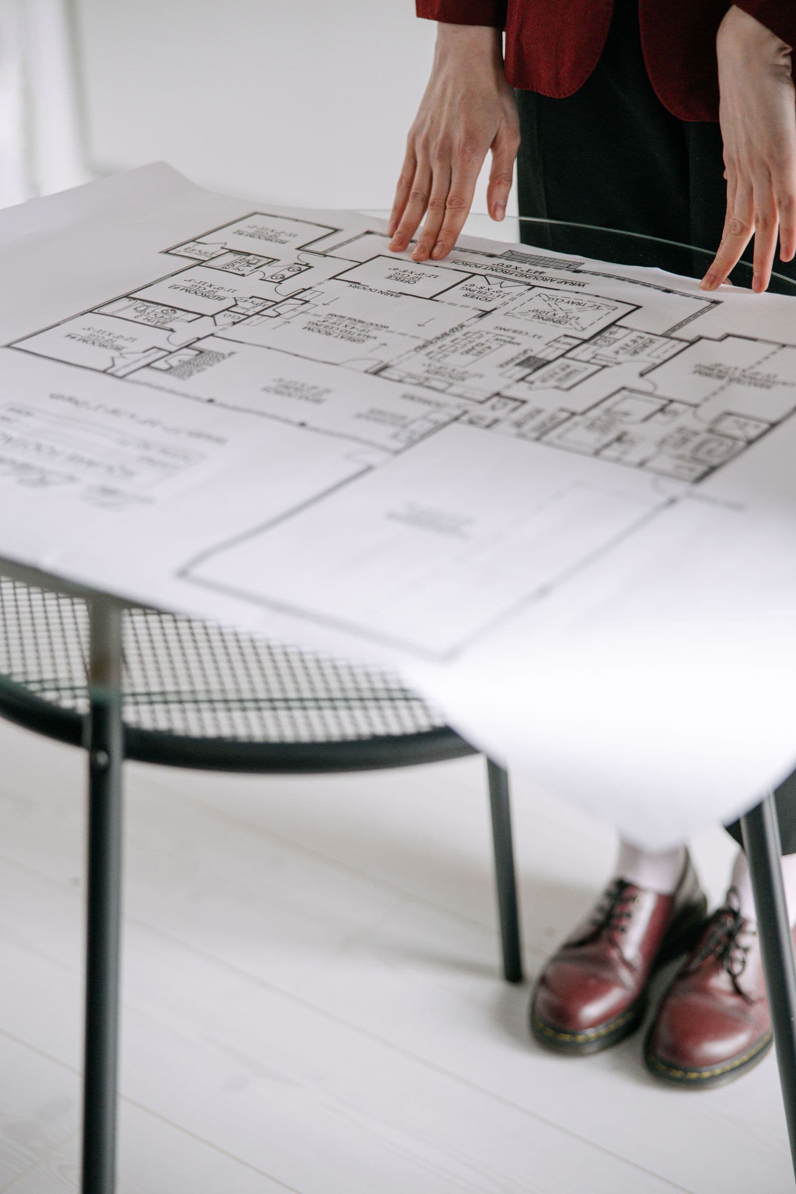 Hands reviewing architectural floor plans on a table