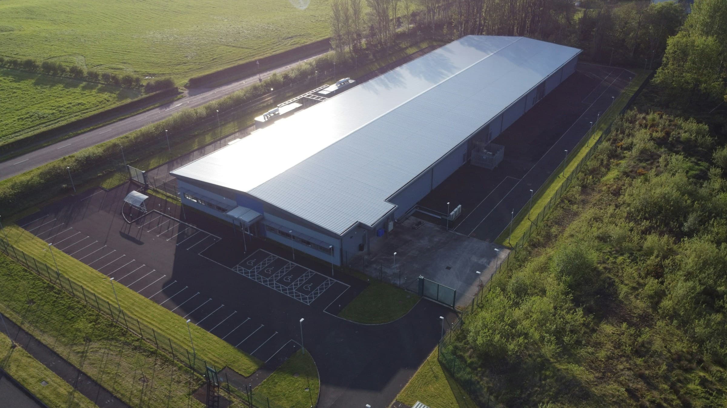 Aerial exterior of a data center building with secure grounds and surrounding greenery